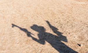 Shadow of a boy with toy guns