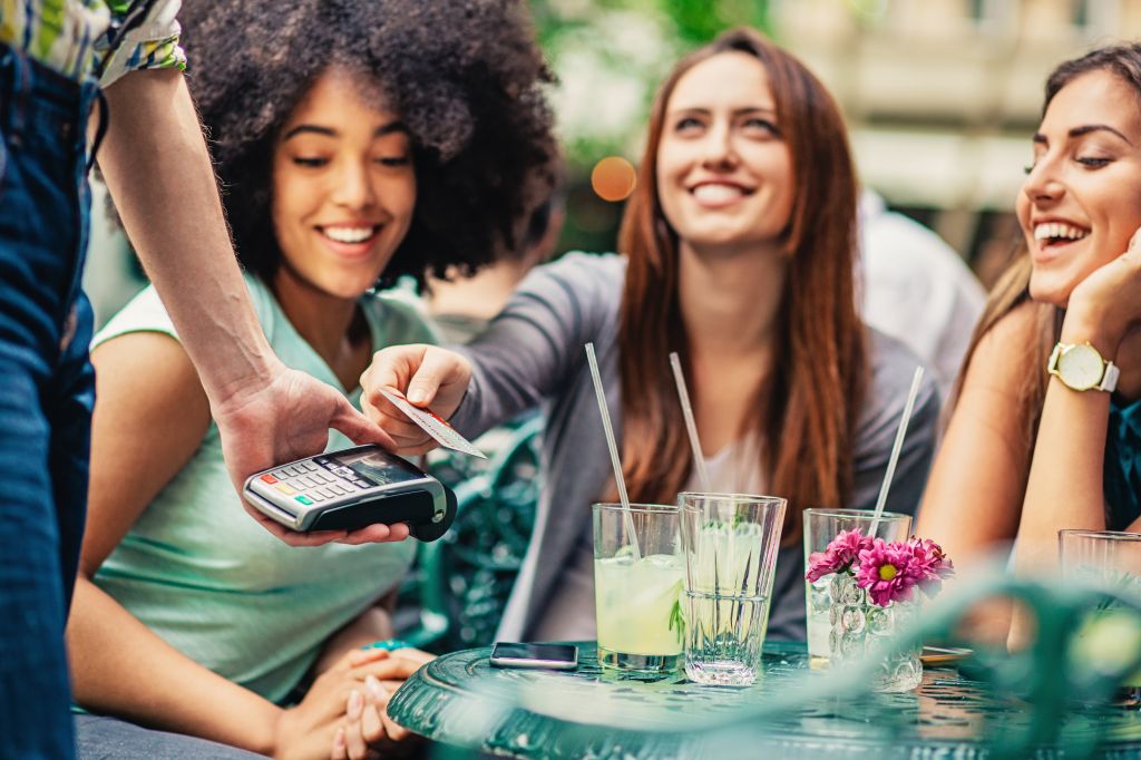 Girlfriends in cafe making payment