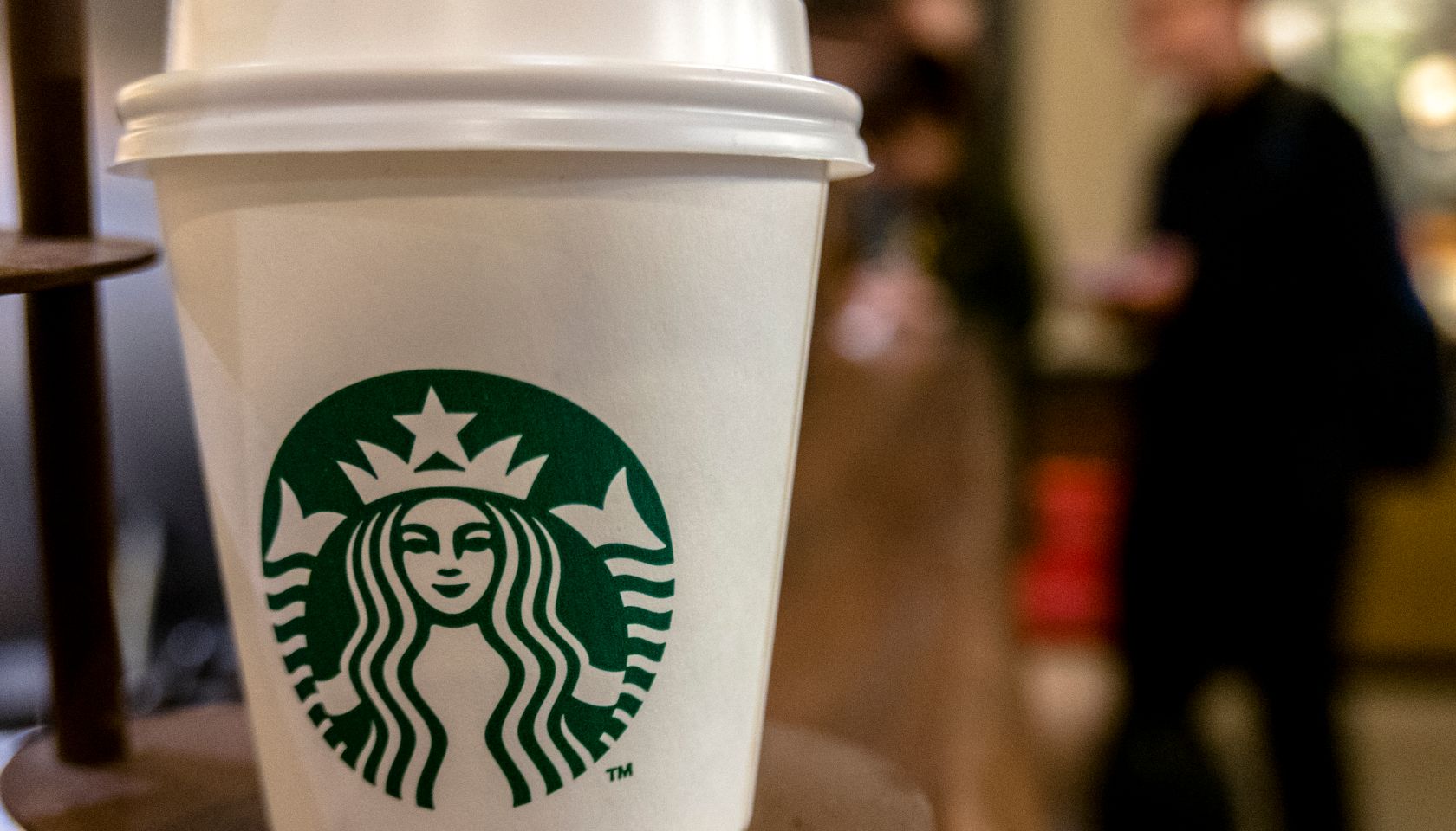 A Starbucks coffee cup on table. Starbucks is growing fast...
