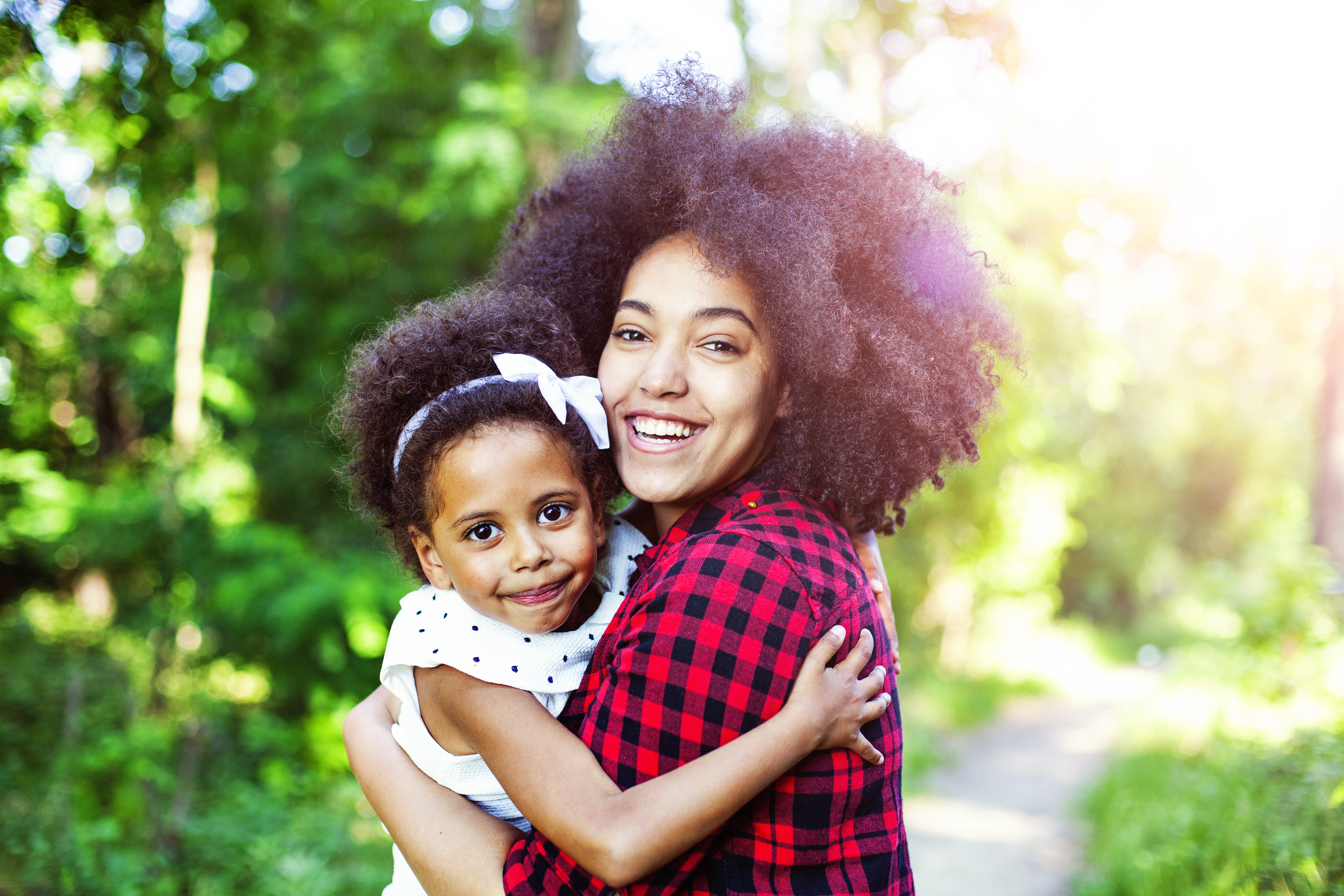 Mother and daughter hugging outdoors