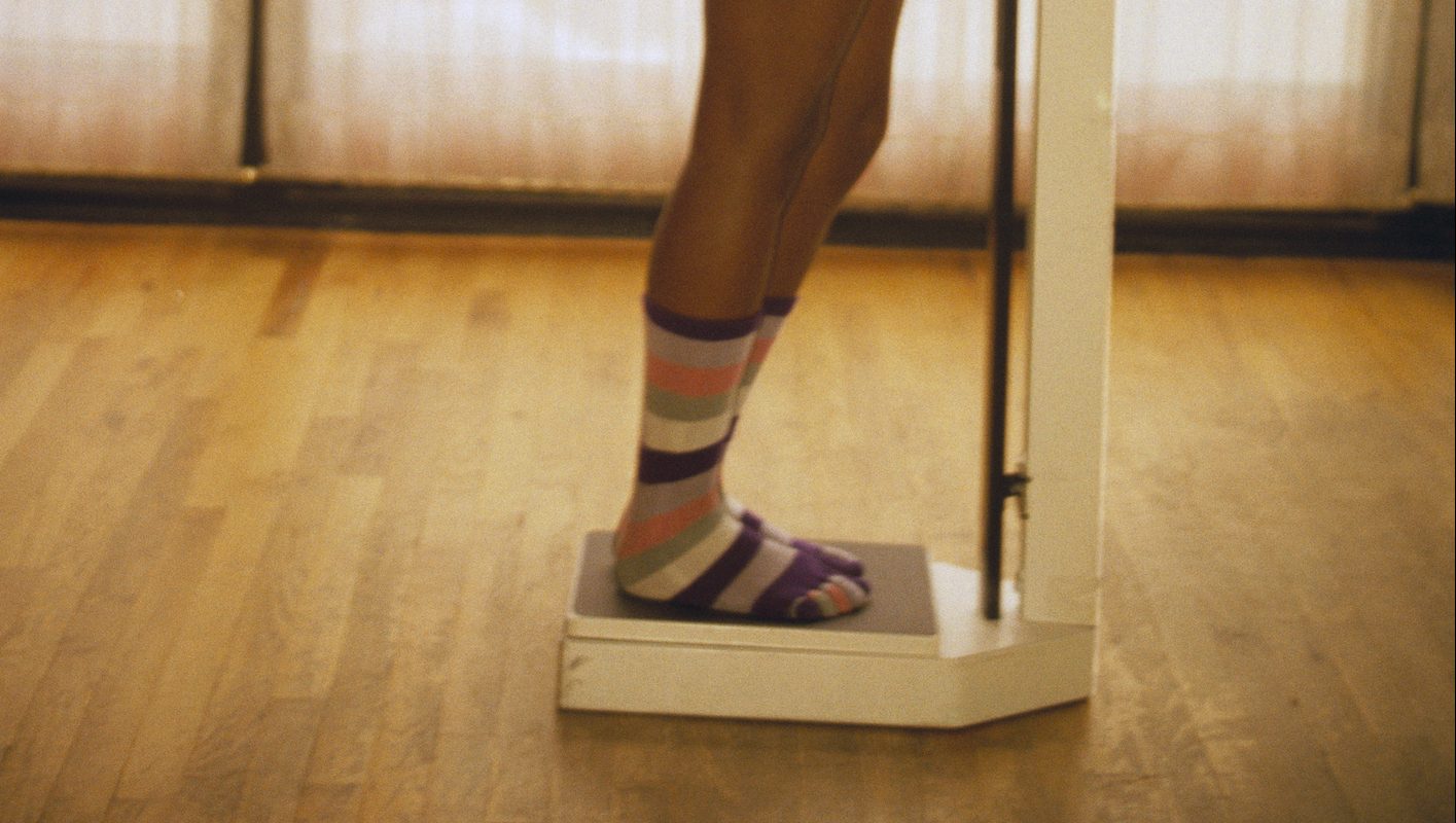 Young Woman Weighing Herself