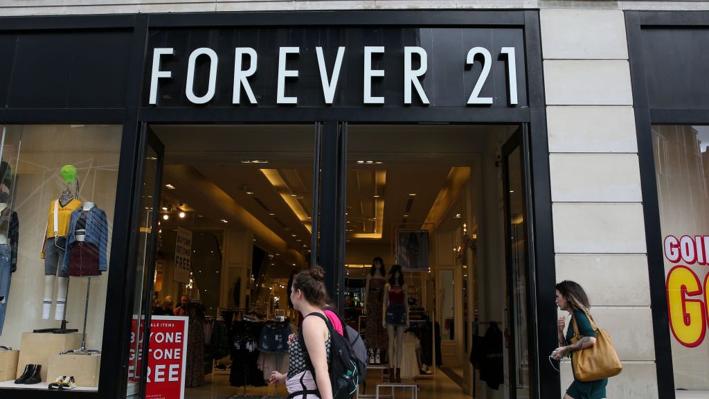 Shoppers walk past a branch of Forever 21 store in central...