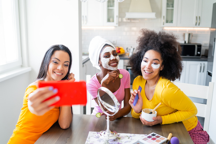 Girls taking good care of their skin, making mask and making selfie