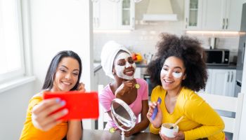 Girls taking good care of their skin, making mask and making selfie