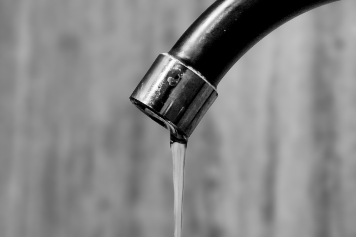 Close up of the sink faucet spouting water