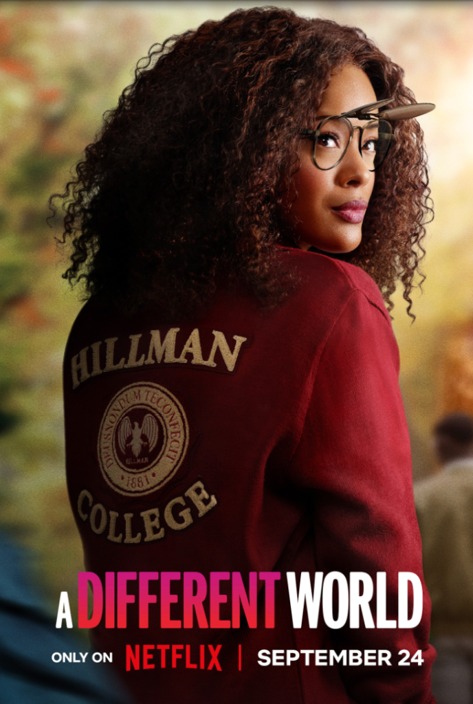 A person with curly hair wearing a red "Hillman College" sweatshirt and glasses, looking off to the side.