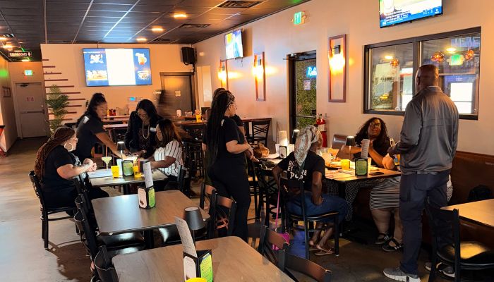 A casual dining restaurant interior with customers seated at tables and booths, enjoying meals and drinks.